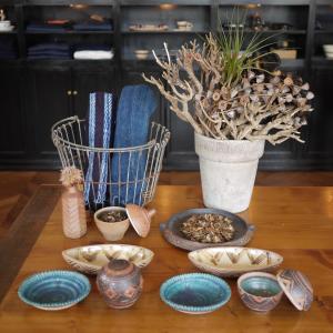 een tafel met platen en een vaas met een plant bij Orrs in Chatan