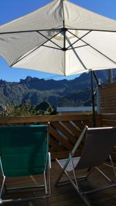 a white umbrella and a chair on a deck at Le Bas de Cilaos in Cilaos