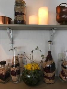 4 botellas en un estante con flores. en Skivarps Gästgivaregård, en Skivarp