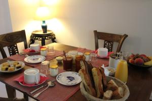 a wooden table with a plate of food on it at La Haute Flourie - bed and breakfast -chambres d'hôtes in Saint Malo
