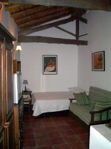 sala de estar con cama y sofá en Apartamentos Rurales Víctor Chamorro del Arco, en Hervás