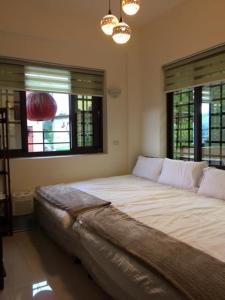 Cama grande en habitación con 2 ventanas en Shan Lan B&B en Fenchihu