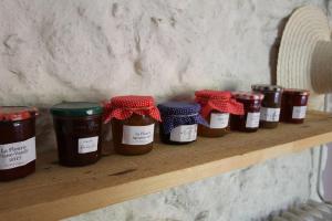 a row of jars of jam on a wooden shelf at La Haute Flourie - bed and breakfast -chambres d'hôtes in Saint Malo
