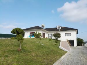 una casa blanca en una colina con un patio en Bed & Breakfast Vista, en Alcobaça