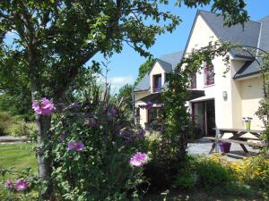 una casa con flores delante en Le Clos des Pommiers en Tracy-sur-Mer