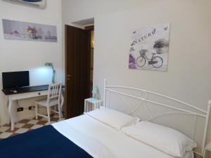 a bedroom with a bed and a desk with a tv at Ortigia Basic -Locazione Turistica in Siracusa