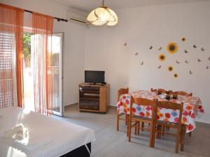 a living room with a table with chairs and a television at Apartment Summer Paradise in Novalja