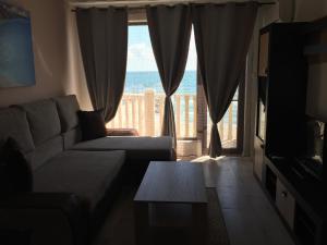 salon z kanapą i widokiem na ocean w obiekcie Apartment Kalni Bani w mieście Pomorie