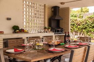 a wooden table with red napkins and wine glasses at Villa Sitges Tupinetti Beach at 1 min walk Amaizing Garden and View Center Sitges 5 minutes walk in Sitges