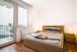 a bedroom with a bed and a large window at Lovely Corvin Apartment in Budapest
