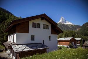 ein Haus mit einem Berg im Hintergrund in der Unterkunft Chalet Talisman in Zermatt