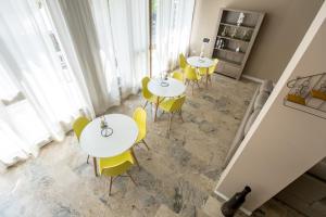 un grupo de mesas y sillas amarillas en una habitación en c-hotels International, en Cattolica