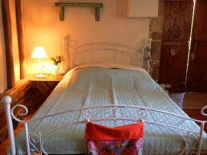 - un lit blanc dans une chambre avec une lampe dans l'établissement Domaine Charente - Familyroom Gypsy with garden (with external toilet & shower house), à Mazières