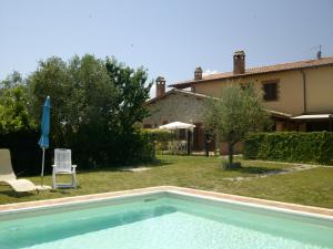 a swimming pool in front of a house at La Loggina Maxi in Tuoro sul Trasimeno