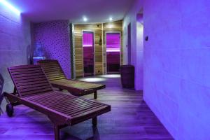 two benches sitting in a hallway with purple lights at Penzion Ajda in Liptovský Mikuláš