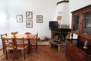 een eetkamer met een tafel en een open haard bij Fattoria Mongerrate in Isnello