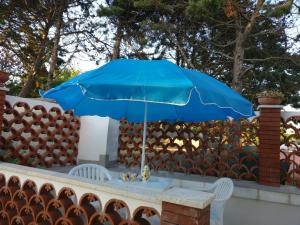 プローチダにあるCasa Parco le Cascineの塀の上に座る青い傘