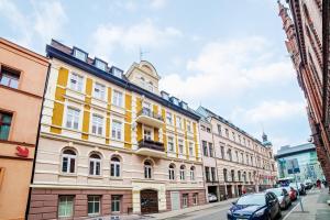 a yellow and white building on a city street at Apartamenty Pocztowa in Bydgoszcz