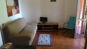 a living room with a couch and a television at Splendida Villetta vicino al mare in Villasimius