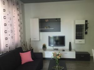 a living room with a black couch and a tv at Apartman Dujmović in Split