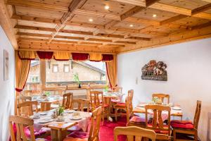 un restaurant avec des tables et des chaises en bois et une fenêtre dans l'établissement Hotel Garni Ernst Falch, à Sankt Anton am Arlberg