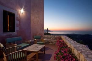 a patio with a table and chairs and flowers at Kastellos Traditional Houses in Kástellos