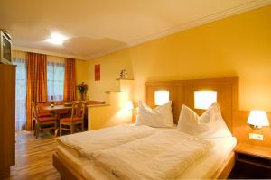 una habitación de hotel con una cama grande y una mesa en Haus Alpenquell, en Hüttschlag