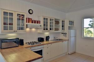 una cucina con armadietti bianchi e frigorifero bianco di "Seasons of Maleny B&B" a Maleny