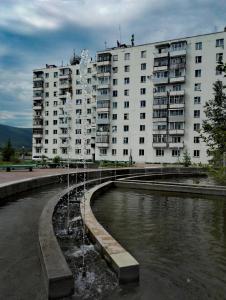 レンスクにあるApartments on Naberezhnayaの池を前にした大きなアパートメントビル