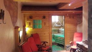 una habitación con sillas rojas y una habitación con ventana en Haus Alpenquell, en Hüttschlag