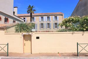 a building behind a wall with a fence at B&B Coup de Coeur in Bram