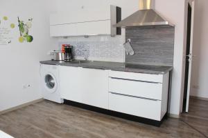 une cuisine blanche avec un lave-linge. dans l'établissement Hafencity Apartments, à Tönning