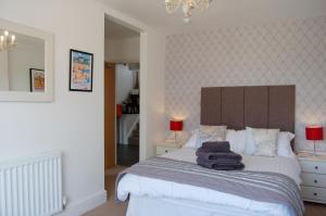 a bedroom with a bed with towels on it at Saint Cadfans Lodge in Tywyn