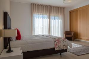 AmoreiraにあるVilla Golf 10のベッドルーム1室(ベッド1台、大きな窓付)