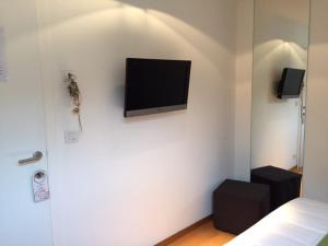 een slaapkamer met een flatscreen-tv aan de muur bij Hotel Le Clos des Récollets in Durbuy