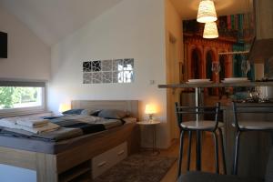 a bedroom with a bed and a kitchen with a bar at Luma 2 in Osijek