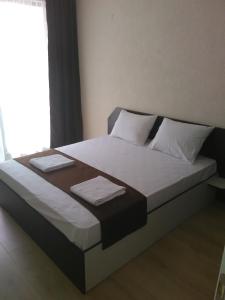 ein Bett mit zwei Handtüchern darauf in einem Schlafzimmer in der Unterkunft Apartments Hristovi in Sandanski
