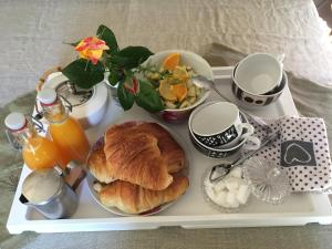 a tray of food with a breakfast of croissants and juice at Le Mas Sylva in La Barriére