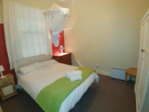 a bedroom with a bed with two towels on it at Sons of the King Guest House in De Rust