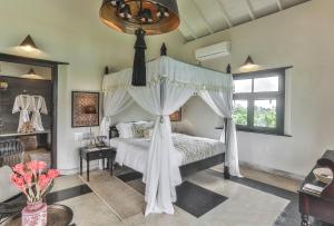 a bedroom with a canopy bed and a window at Villa Mayurana by Edwards Collection in Koggala +69 photos