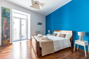 a blue bedroom with a bed with towels on it at Piazza Marina Holiday House by DomuSicily in Palermo