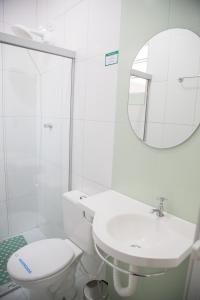 y baño con aseo, lavabo y espejo. en Hotel Turiassú, en São Paulo