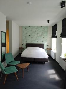 ヘントにあるB&B Baudeloのベッドルーム1室(ベッド1台、緑の椅子付)