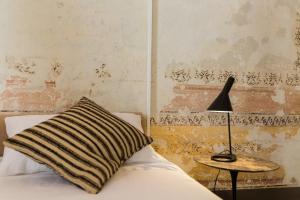 a bed with a pillow and a lamp on a table at Casatorre dei Leoni Dimora Storica in Siena