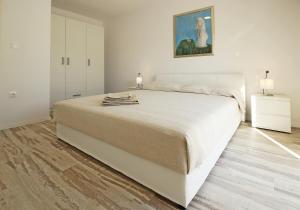 Apartments Mocici في سيليبي: غرفة نوم بسرير كبير ولوحة على الحائط
