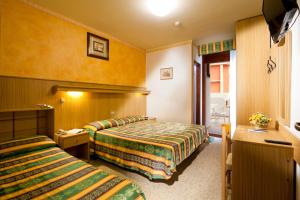 una camera d'albergo con due letti e una finestra di Hotel Kennedy a Bibione