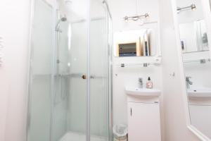 baño blanco con ducha y lavamanos en Blómasetrið Homestay, en Borgarnes 37 fotos más