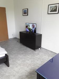 um quarto com uma televisão de ecrã plano na parede em Pension zum Bauhof em Zwickau