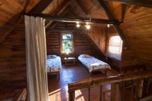 an attic room with two beds in a log cabin at A Log Home at Buffalo Creek in Buffeljagsrivier