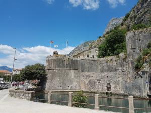 a large stone wall next to a body of water at S&I room in Kotor
